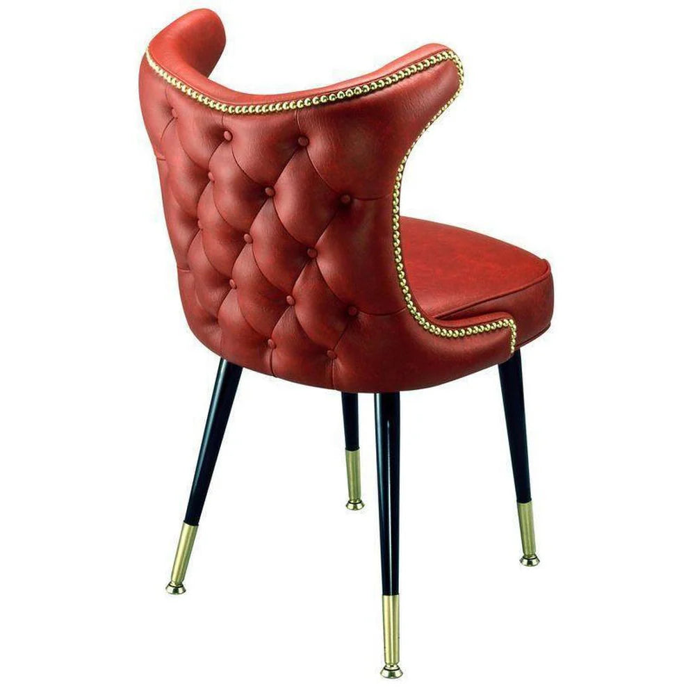 Cowboy-style bucket dining chair with button-tufted back, brass nail trim, and a welded steel base with brass ferrules.