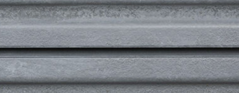 Close-up of corrugated silver metal panel surface with metallic texture.