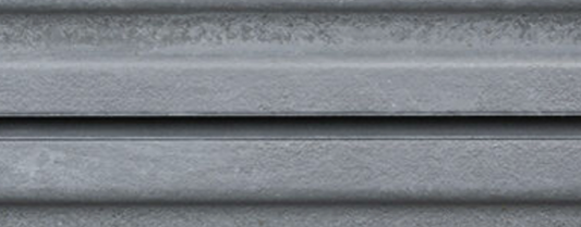 Close-up of corrugated silver metal panel surface with metallic texture.