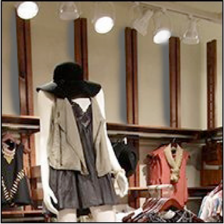 Clothing store interior with racks and mannequins displaying various outfits.