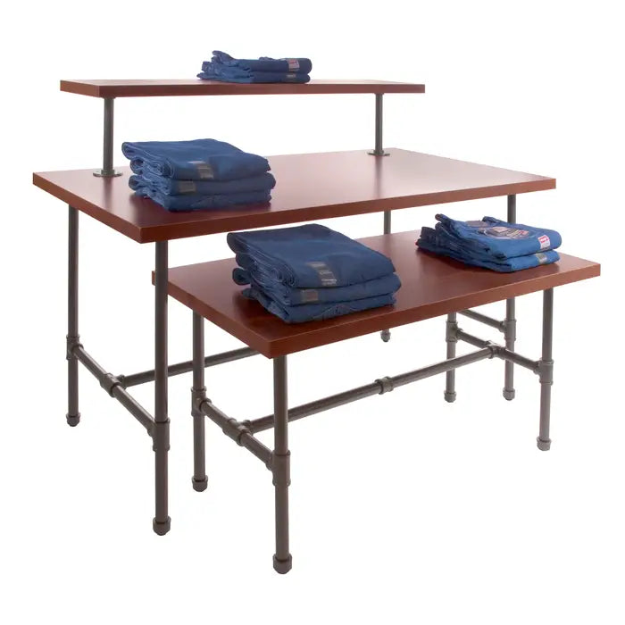 Front view of an industrial pipe merchandising table with a rectangular top and a sturdy 1¼-inch pipe frame available in multiple finishes for retail and hospitality displays.