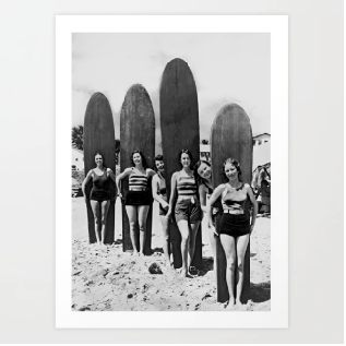 Black and white photo of women with surfboards on a beach