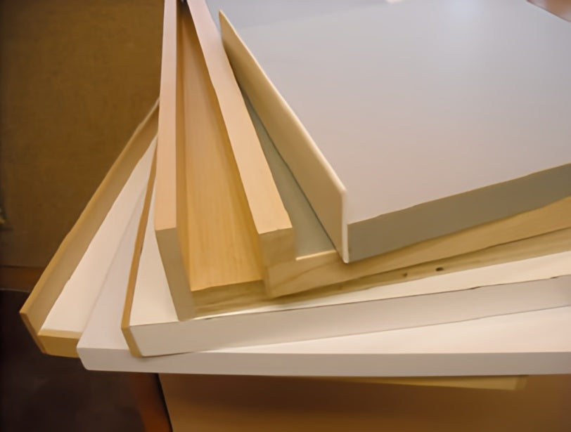 Stack of wooden and white boards on a wooden surface