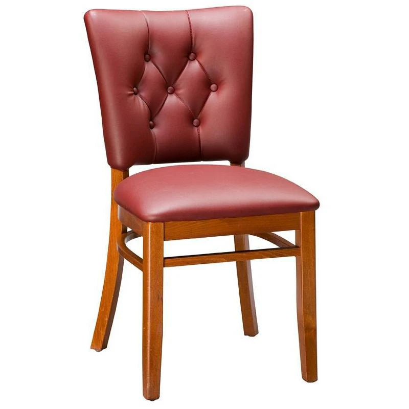 Drake upholstered beech wood dining chair in walnut finish with cream vinyl seat and back, featuring decorative nail trim detailing. Custom wood finishes and upholstery colors available. Made in the USA for restaurants and hospitality interiors.