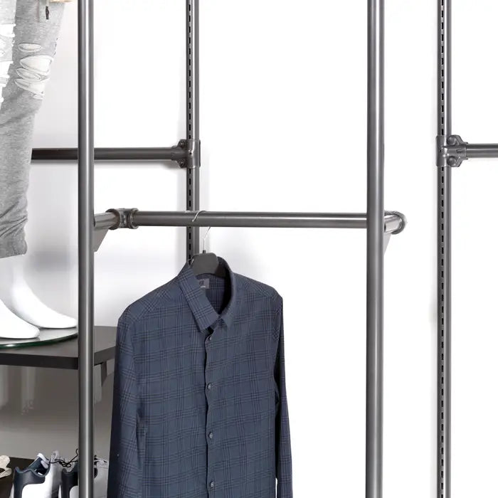 Grey Pipeline hangrail installed on a retail wall display, shown holding apparel to demonstrate its industrial pipe design and functionality within a merchandising system.