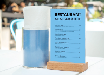 Restaurant menu mockup with a blue background and wooden stand on a blurred outdoor setting.