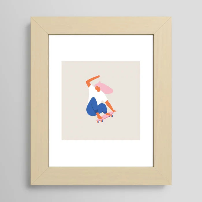 Skateboard Girl art print by Tasiania in a light maple frame, featuring a youthful skateboard scene perfect for art walls, cafés, or bedroom décor