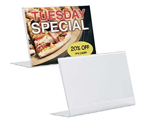 Front view of a clear acrylic slant back sign holder displaying a menu on a countertop.