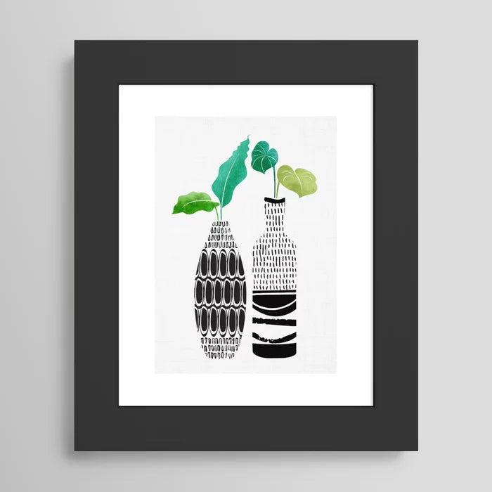 “Modern tropical wall art featuring tribal vases and greenery in black wood frame