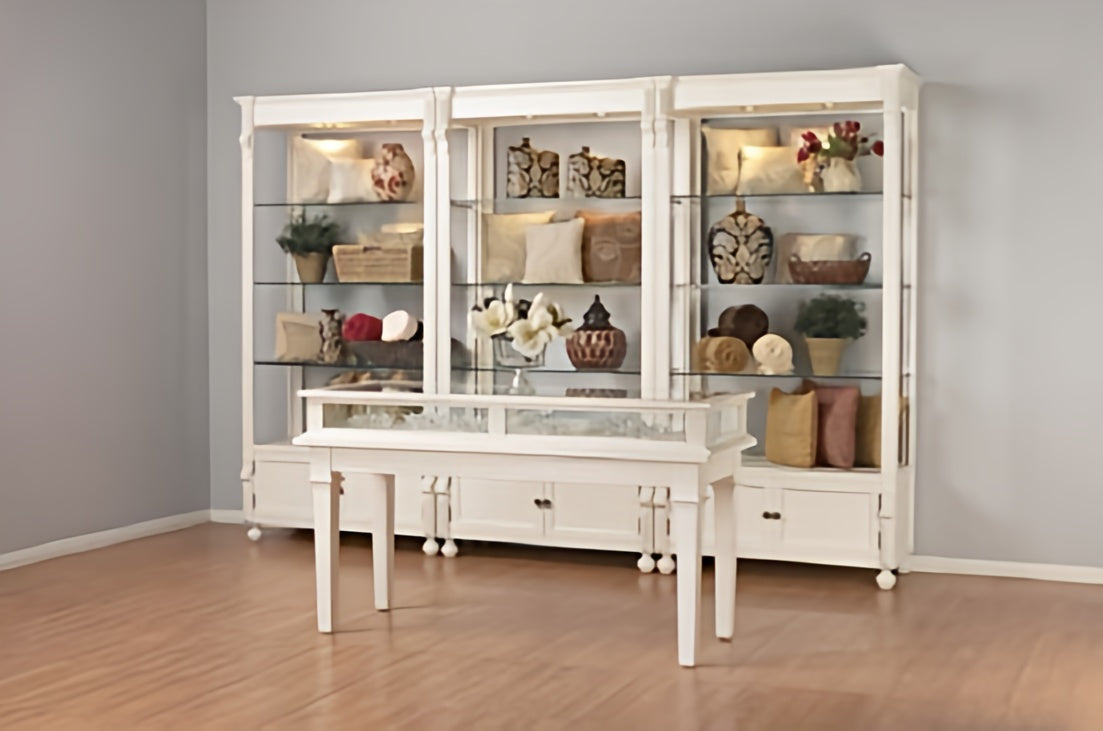 White dining room set with glass display cabinet against a gray wall.